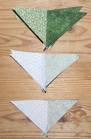 Sew background triangle sets to contrast triangle sets along long edge nesting seams for Ohio Star quilt block